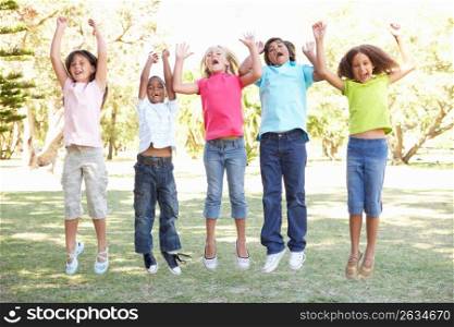 Group Of Children Jumping In Air In Park