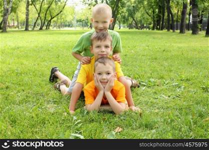 Group of children lying on the grass in the summer park