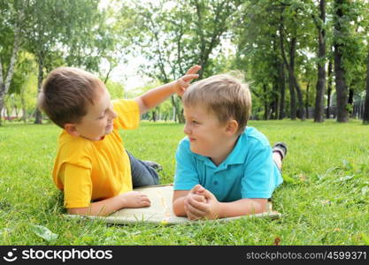 Group of children lying on the grass in the summer park