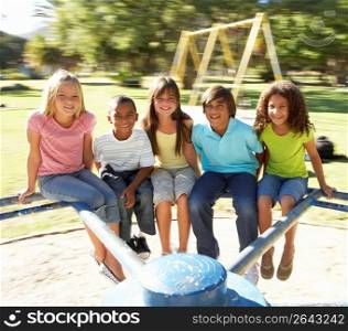 Group Of Children Riding On Roundabout In Playground