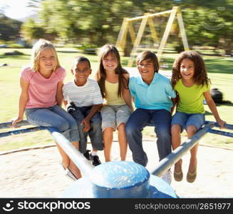 Group Of Children Riding On Roundabout In Playground