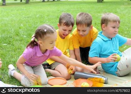 Group of children sitting together on teh grass in the park