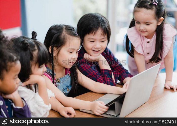 Group of children using laptop in classroom, Multi-ethnic young boys and girls happy using technology for study at elementary school. Kids use technology for education concept.
