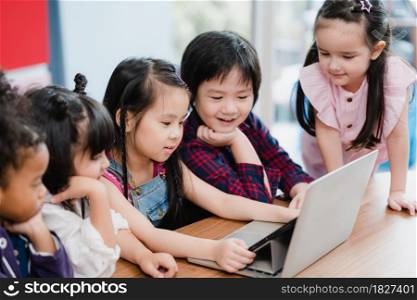 Group of children using laptop in classroom, Multi-ethnic young boys and girls happy using technology for study at elementary school. Kids use technology for education concept.
