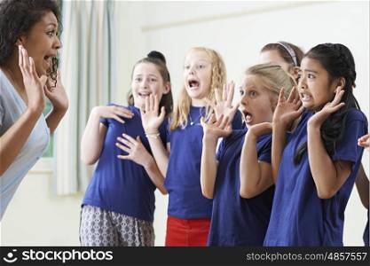 Group Of Children With Teacher Enjoying Drama Class Together