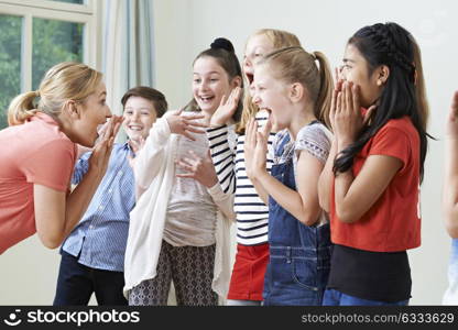 Group Of Children With Teacher Enjoying Drama Class Together