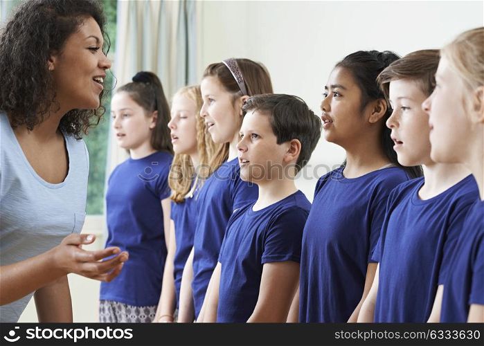 Group Of Children With Teacher Enjoying Singing Group