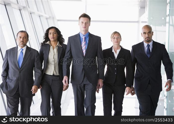 Group of co-workers walking in office space (high key)
