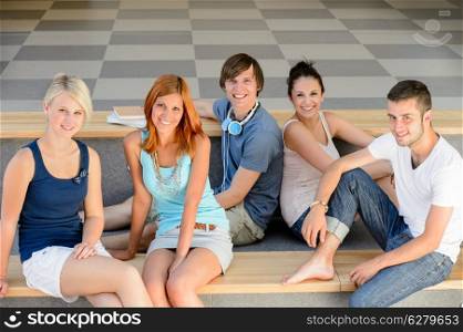Group of college student friends sitting on bench looking camera