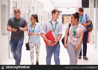Group Of College Students Walking Along Corridor