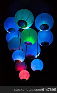 Group of colored paper lanterns glowing in the dark