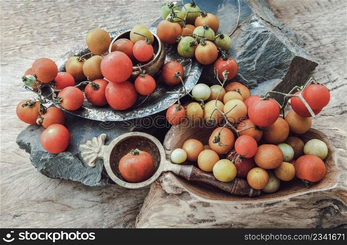 Group of Colorful variety of Fresh wild tomatoes (Mini Cherry Tomatos) on old wooden board background. Top view, Selective focus.