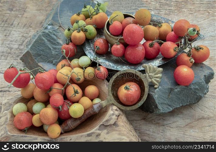 Group of Colorful variety of Fresh wild tomatoes (Mini Cherry Tomatos) on old wooden board background. Top view, Selective focus.