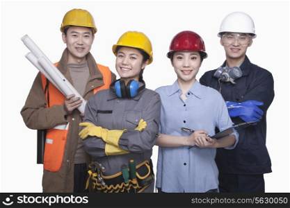 Group of construction workers standing against white background, smiling, portrait