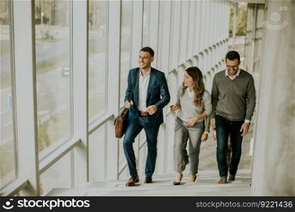 Group of corporate business professionals climbing at stairs in office corridor on a sunny day