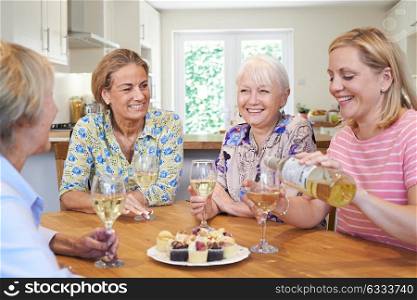 Group Of Different Aged Female Friends Relaxing At Home And Drinking Wine
