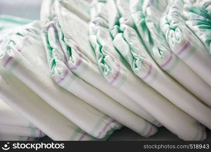 Group of disposable diapers arranged over a white changing table. Hygiene and health care for baby