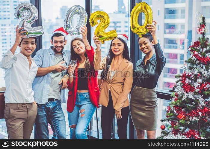 Group of diversity colleague teamwork celebaring for New Year party 2020 in modern urban office background. Friends having enjoy party with alcoholivd drinks together. Multi ethics people lifestyles.