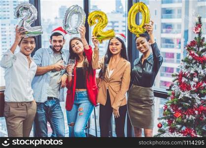 Group of diversity colleague teamwork celebaring for New Year party 2020 in modern urban office background. Friends having enjoy party with alcoholivd drinks together. Multi ethics people lifestyles.