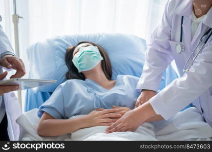 Group of Doctor try to help patient woman lie on hospital bed and holding on stomach suffering. Abdominal pain that comes from menstruation, diarrhea, or indigestion. Sickness and healthcare concept