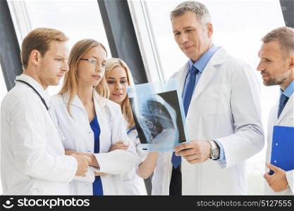 Group of doctors discuss x-ray. Group of doctors look and discuss x-ray in a clinic or hospital