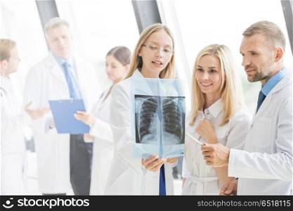 Group of doctors discuss x-ray. Group of young doctors look and discuss x-ray in a clinic or hospital