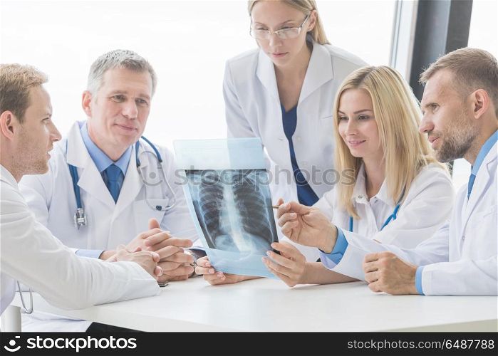 Group of doctors looking at x-ray. Healthcare, medical and radiology concept - group of doctors looking at x-ray