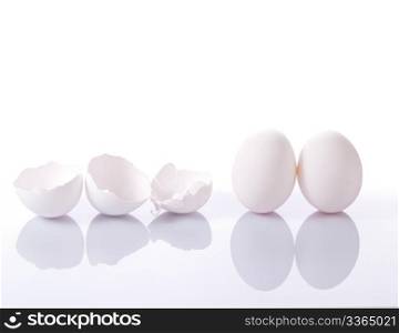 Group of eggshells and eggs with reflection on white background