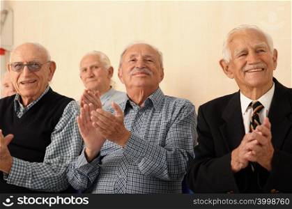 Group of elderly men applauding