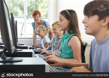 Group Of Elementary Pupils In Computer Class With Teacher