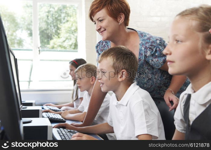 Group Of Elementary Pupils In Computer Class With Teacher