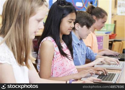 Group Of Elementary School Children In Computer Class