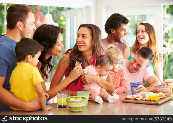 Group Of Families Enjoying Snacks At Home