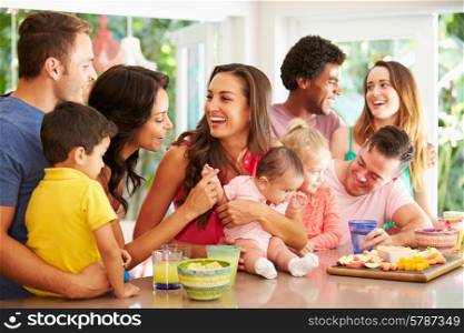 Group Of Families Enjoying Snacks At Home