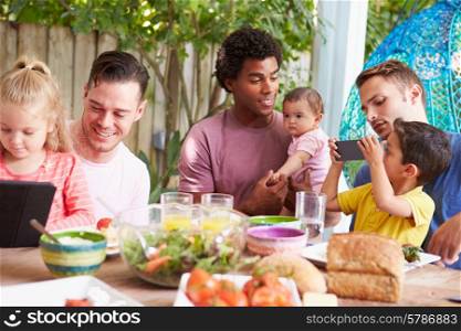 Group Of Fathers With Children Enjoying Outdoor Meal At Home