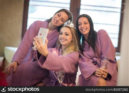 group of female friends in spa have fun and making selfie photo with mobile phone, celebrate bachelorette party