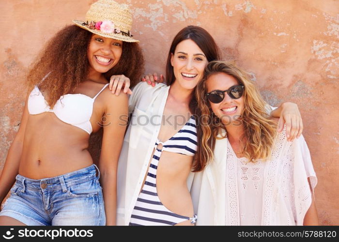 Group Of Female Friends On Holiday Together Posing By Wall