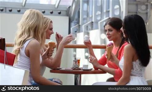 Group of female friends talking and laughing in cafe