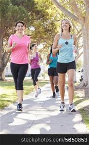 Group Of Female Runners Exercising On Suburban Street