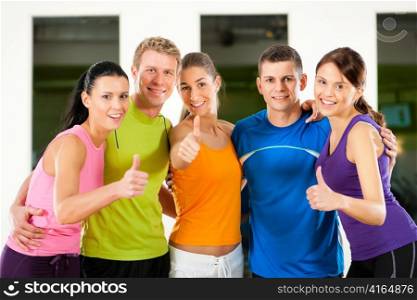 Group of five people exercising in gym or fitness club