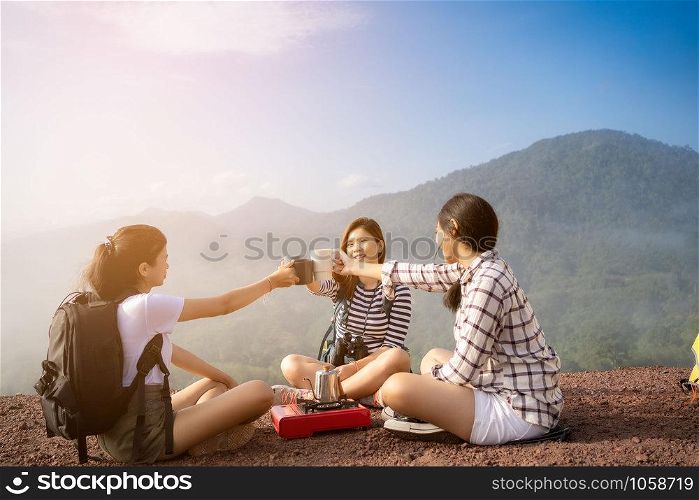 Group of Friends asian camp nature. Adventure Travel Relax Concept, mountain view.Group of Asian female tourists at the camp and drinking coffee in the mountains.