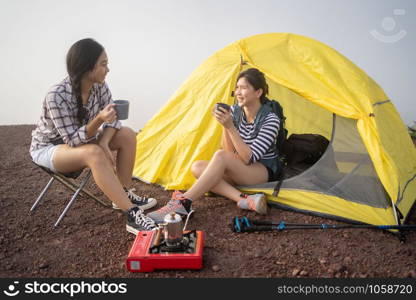 Group of Friends asian camp nature. Adventure Travel Relax Concept, mountain view.Group of Asian female tourists at the camp and drinking coffee in the mountains.