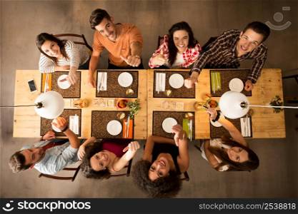Group of friends at a restaurant looking up with thumbs up