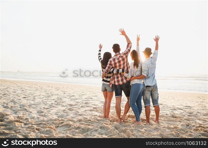 Group of friends at the beach and enjoying the sunset