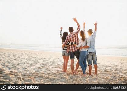 Group of friends at the beach and enjoying the sunset