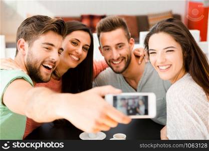 Group of friends at the coffee shop making a selfie together