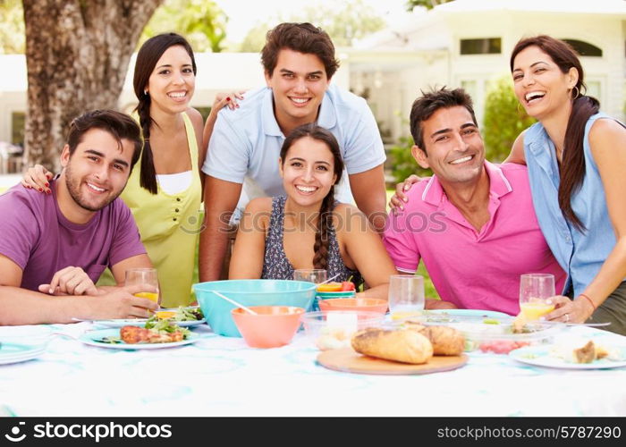 Group Of Friends Celebrating Enjoying Meal In Garden At Home