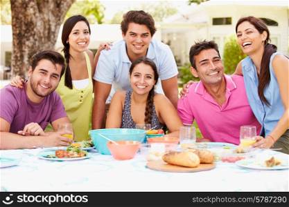 Group Of Friends Celebrating Enjoying Meal In Garden At Home