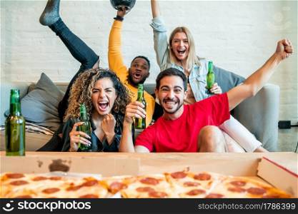Group of friends celebrating victory while watching a match together. Friends and sports concept.
