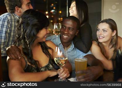 Group Of Friends Enjoying Drink At Bar Together